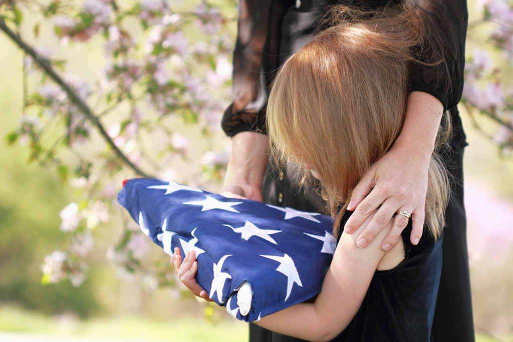 Child Mourning Holding A Flag